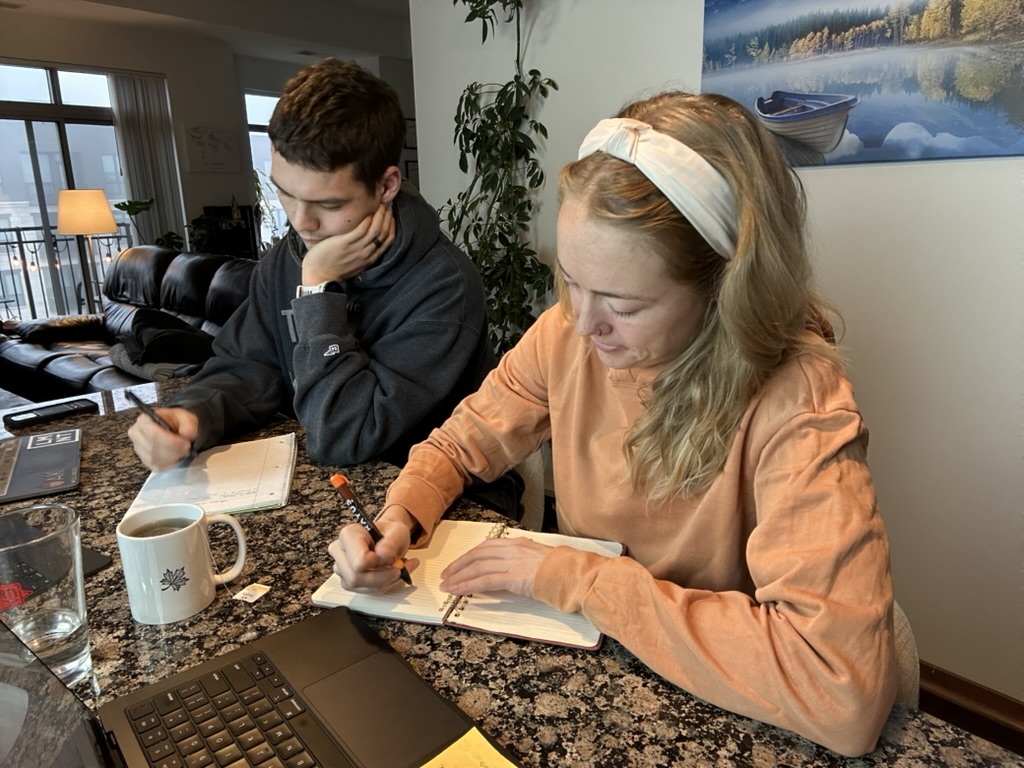 Dr. Kailee and Jacob writing in journals and setting holistic wellness goals